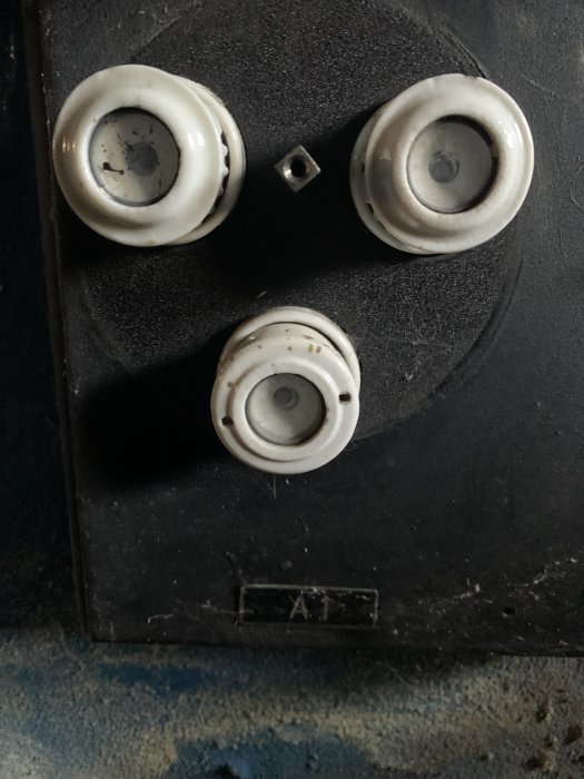Elektrisk säkringsbox med tre keramiksäkringar, en ser ut att ha smält.