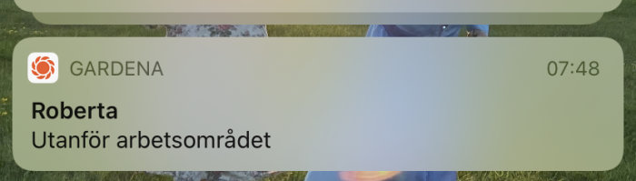 Notis på iPhone med texten "GARDENA Roberta Utanför arbetsområdet" visar ett larm från en robotgräsklippare.