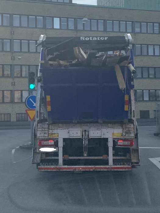 Lastbil full med bråte fotograferad bakifrån på gata i Göteborg, regnummer överkladdat.