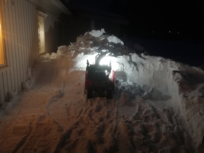 Hondas största bandslunga i arbete med att flytta snö vid en bostad på kvällen.