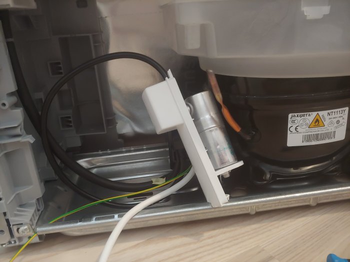 Kompressor och startrelä för Siemens kylskåp modell KG36VVI32/09 med synlig ledningskoppling.