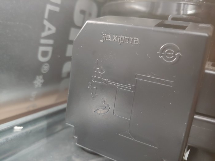 Startrelä på en kylskåpskompressor med modellnummer och installationsanvisningar synligt.