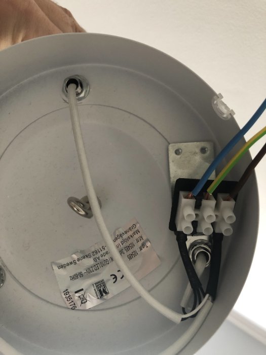 Nyinstallerad taklampa med elanslutningar synliga i takdosan innan montering av lampkåpan.