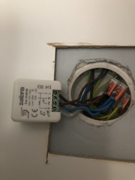 Elektrisk anslutningsdosa med flera kablar monterad i vägg bakom garderob.