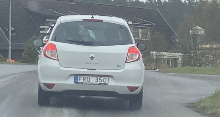 Vit Renault Clio bakifrån med registreringsskylt som lyder "FRU 350" på en väg.