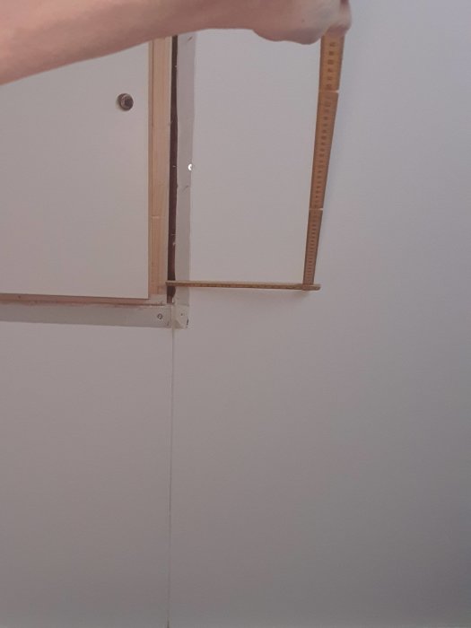 Mätning av springa på insidan av en taklucka som kan vara orsak till mögelproblem.