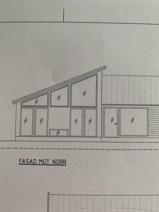 Ritning av husfasad mot norr med flera fönster, vissa under snedtak.