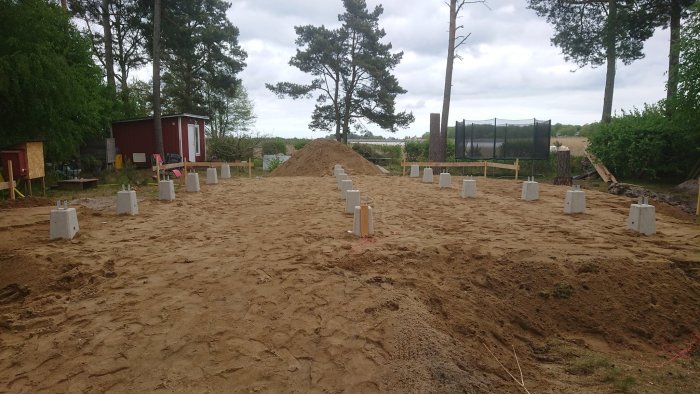 Betongplintar i rader med stolpskor i en pågående byggprojektsmark.