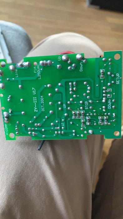 Närbild på kretskortet från en motordriven projektorduk som visar lödningar och kopplingar.
