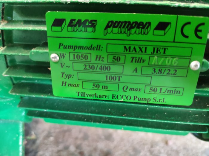 Grönt etikett på en E.M.S MAXI JET 100T pump med tekniska specifikationer som watt, volt, och ampere.