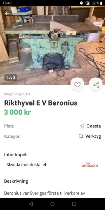 En använd, grön industririkthyvel i ett verkstadsutrymme med blåa och vita färger på maskinen.