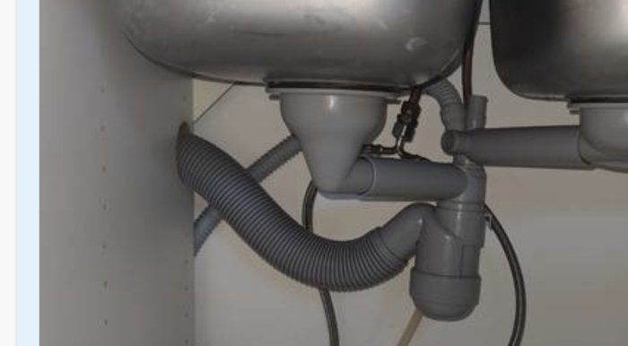 Rörinstallation under handfat med felaktig lutning och komplicerad rördragning.
