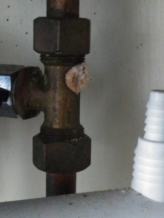 Rostigt varmvattenrör med smulande isoleringsmaterial påkopplat i en installation.