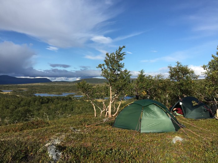 Tältläger i Jämtlandsfjällens vidsträckta landskap med sjöar och berg i bakgrunden.