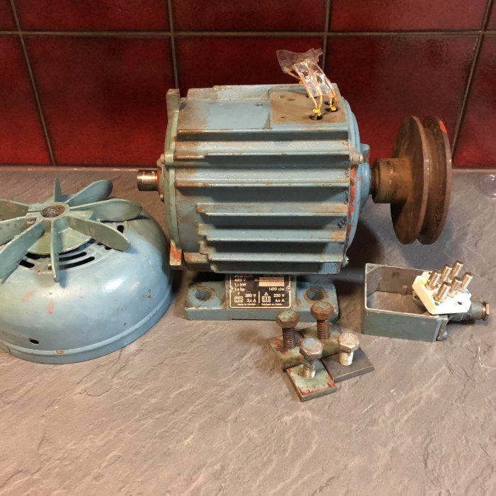 En gammal ASEA MBB9 1.1kW/1.5HP elmotor med tillhörande delar och fläkt på en bänk.