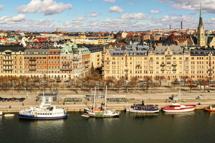 Utsikt över Strandvägen med historiska byggnader och båtar längs kajen i Stockholm.