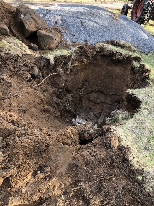Provgrävhål i sandig mark med synlig vattenansamling cirka 50 cm under marknivå.