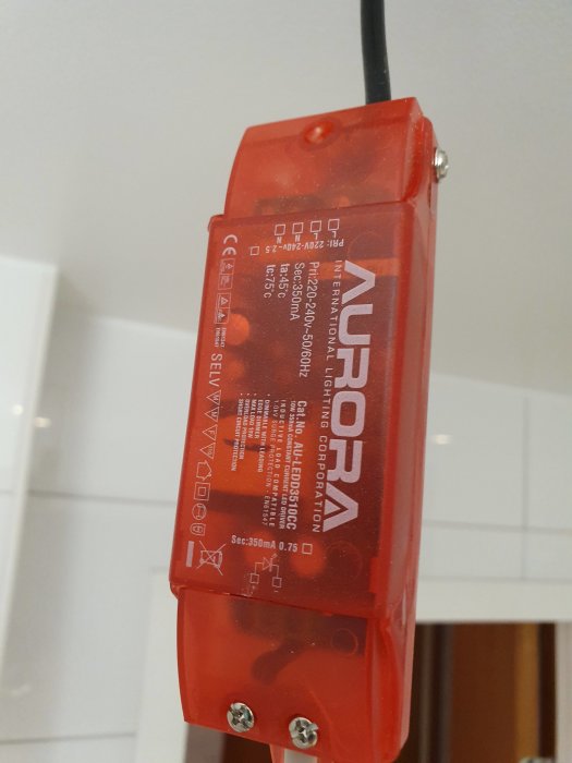 Röd Aurora transformator för LED-spottar monterad på vägg.
