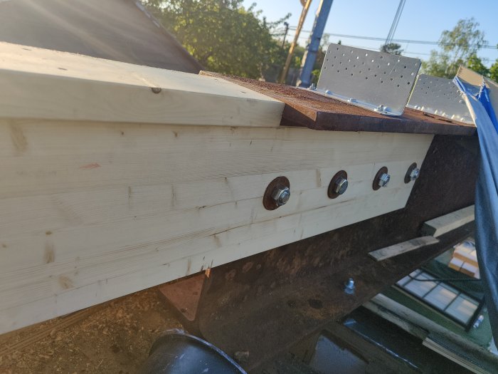 Förlängd HEB-balk med limträ, gipsskivor som distanser och M24 bultar för konstruktionstabilitet.