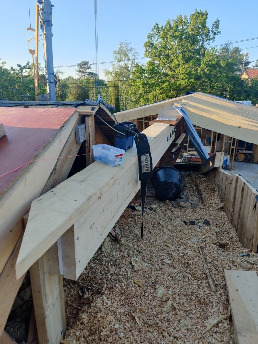 Konstruktionsarbete med förlängning av HEB balk och montering av limträ i takstomme på ett bygge.