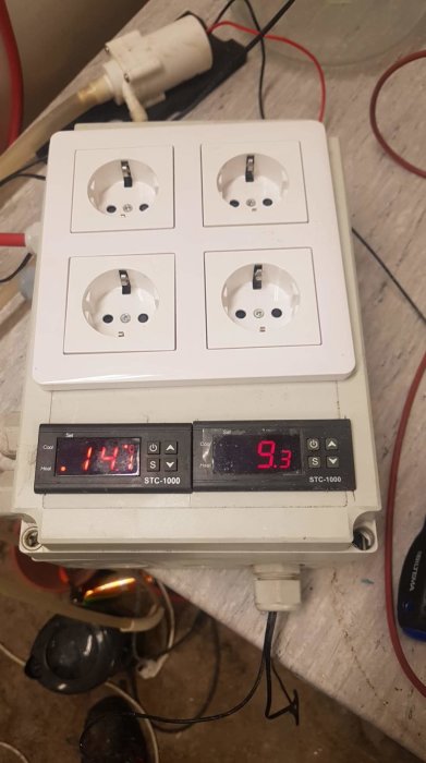 Väggmonterad elcentral med fyra eluttag och en temperaturregulator med digital display som visar 14.3°C och 9.3s.
