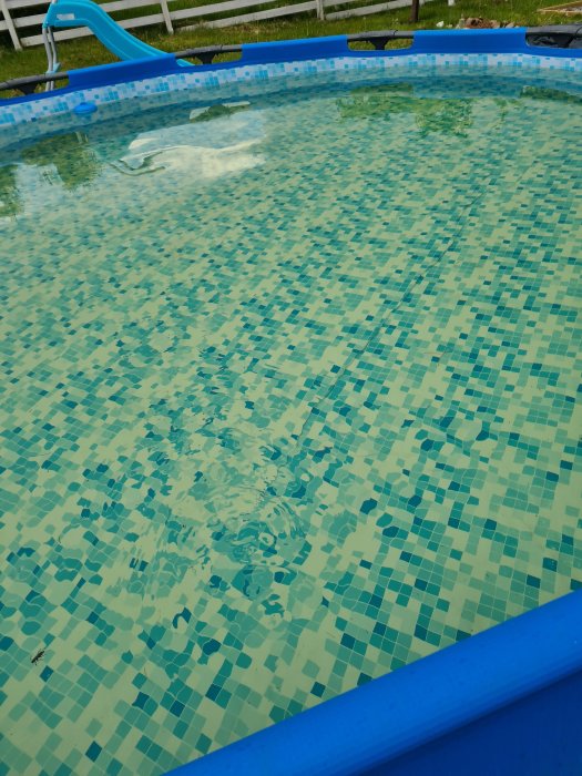Ram pool med gulaktigt vatten, ej gulfärgad poolduk synlig ovanför vattnet.