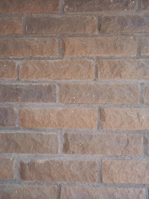 Närbild på en brun tegelfasad som kan passa för kulördiskussioner till 70-talshus.