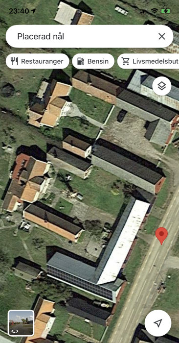 Satellitbild över en tomt med byggnader som kan inkludera ekonomibyggnader och en potentiell hemfridszon.