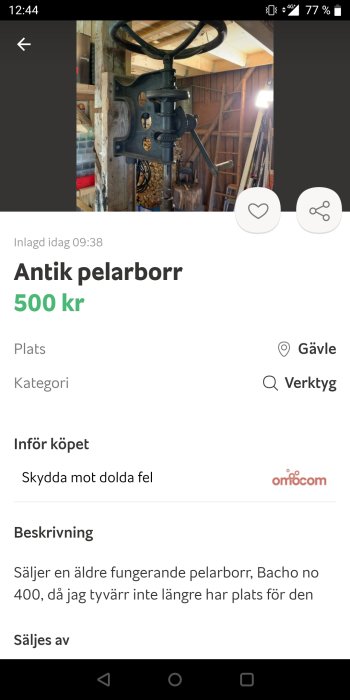 Antik pelarborr fastmonterad på en träpelare i ett verkstadsutrymme.