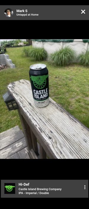 En burk öl från Castle Island Brewing Company på ett slitet träbord utomhus.