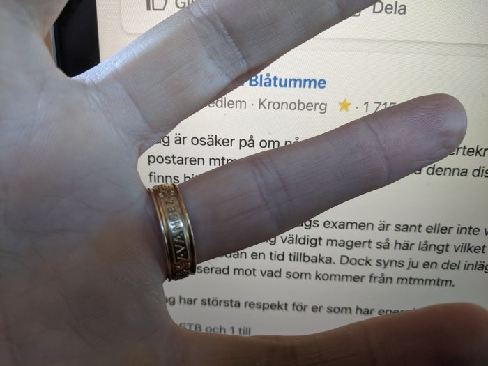 Hand visar en ChalmersRing framför en datorskärm med text.