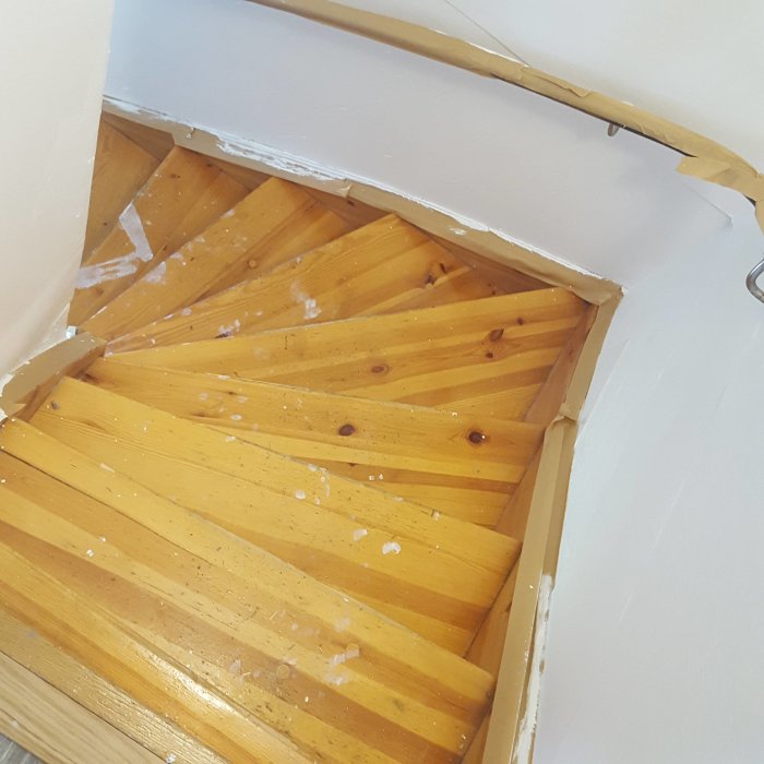 Ommålad furutrappa med halvmålade vita sidoväggar och tejpade kanter.