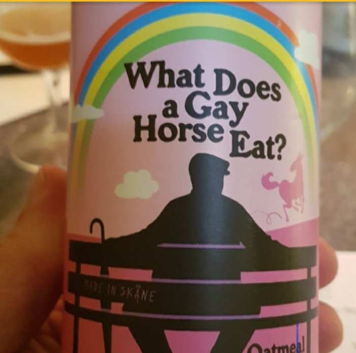 Etikett på en ölflaska med regnbåge och texten "What Does a Gay Horse Eat?" samt orden "Made in Skåne".