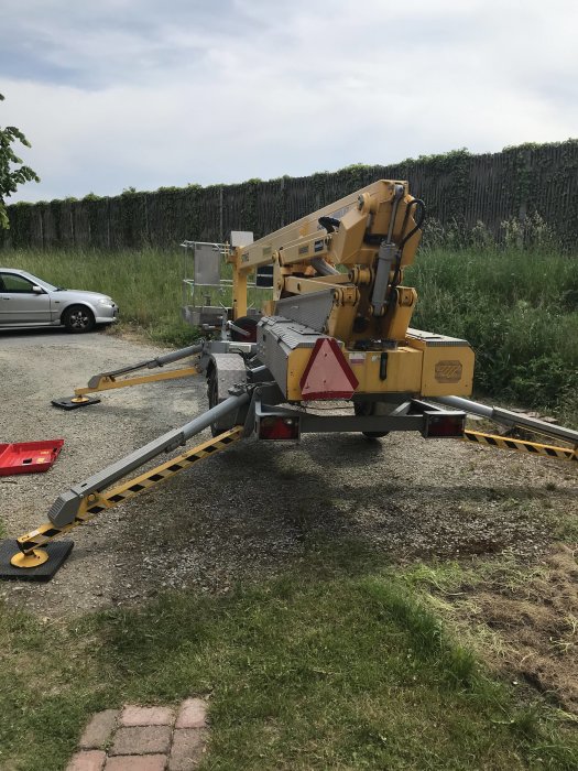 Mobil arbetslift parkerad utomhus används för projekt i hemmet.