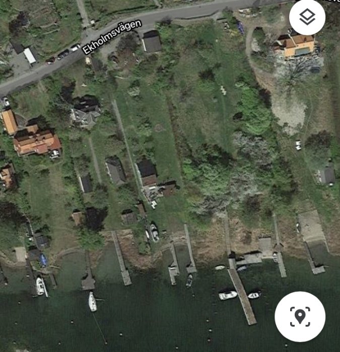 Flygbild över Älgö med bostäder och bryggor, vissa bryggor ligger inom och andra utom fastighetsgränser.