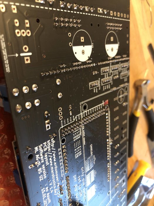 Närbild av ett kretskort med många lödpunkter och elektroniska komponenter.