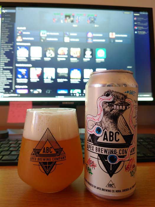 Ölglas och burk från Apex Brewing framför datorskärm visande ett forum eller gränssnitt.