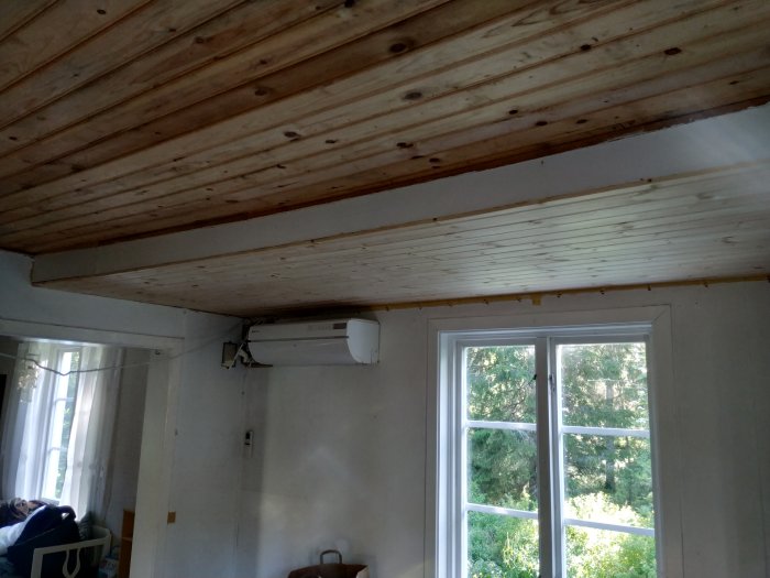 Tak med pärlspont och synlig sviktning ovanför fönster i ett rum under renovering.