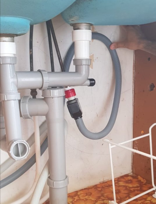 Installation av diskmaskinslangar med inloppsslang hängande som ett omvänt U under diskbänken.