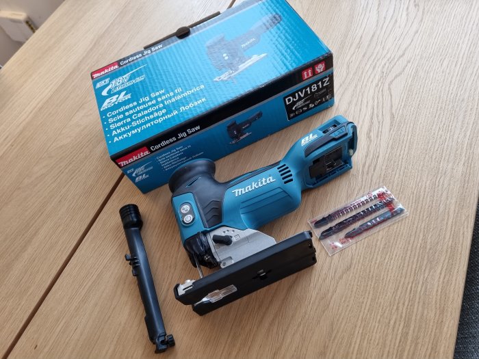 Makita 18v sticksåg med förpackning och sågblad på ett bord.