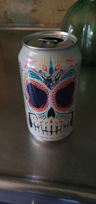 Aluminiumburk med färggladd design av dödskalle i stil med "Dia de Muertos" på en köksbänk.