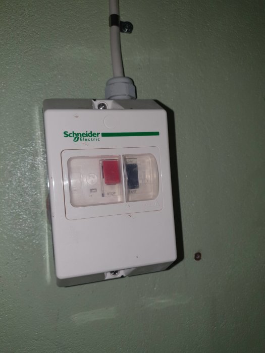 En Schneider Electric säkringsbrytare monterad på en vägg.