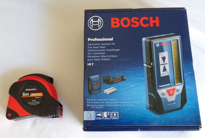 Bosch lasermottagare i kartong och Hultafors måttband, nyligen köpta med prismatchning.