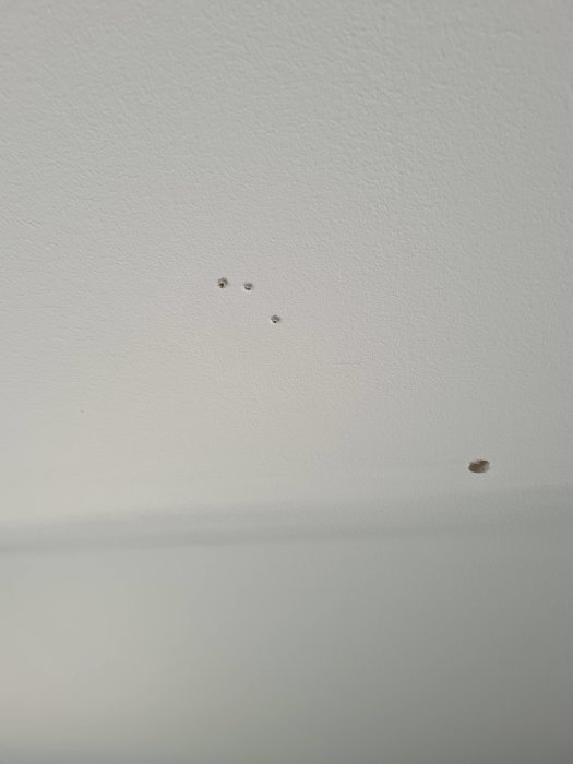 Vitt tak med små skruvhål och ett större 10mm hål i köket som behöver lagas.