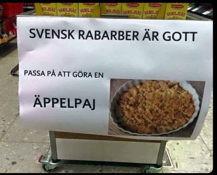 Skylt med texten "SVENSK RABARBER ÄR GOTT" och "PASSA PÅ ATT GÖRA EN ÄPPELPAJ" bredvid en bild på en äppelpaj.