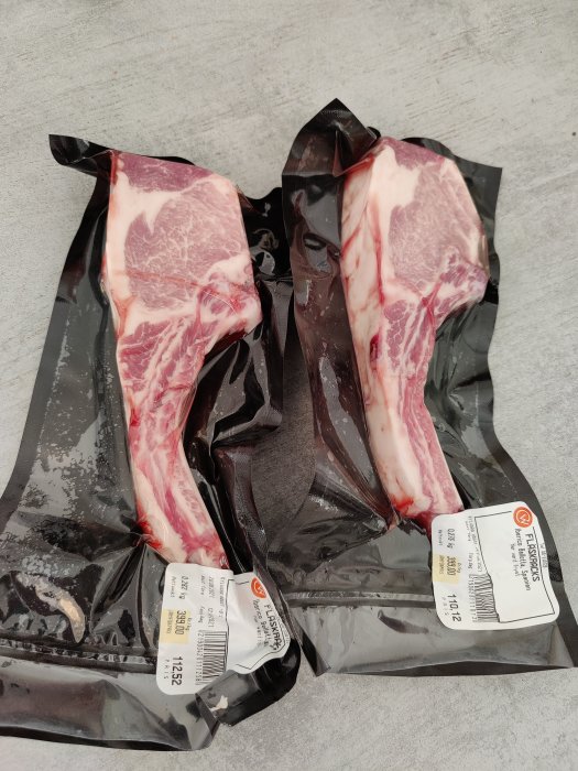 Förpackade iberico racks redo för grillning på en grå yta.
