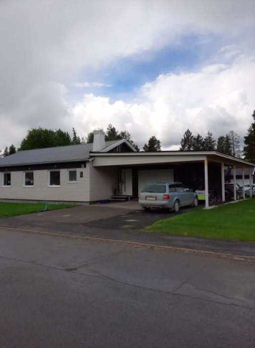 Enfamiljshus med nytt förlängt garagetak som bildar carport, bil parkerad under.