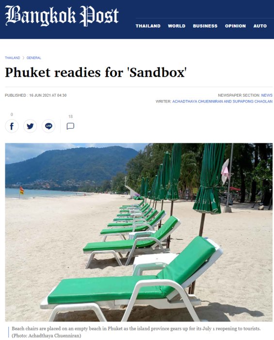 Solstolar på en tom strand i Phuket med hopfällda gröna parasoller i bakgrunden.