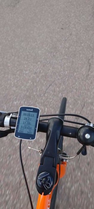 Cyklistperspektiv av en cykelstyre med en Garmin GPS cykeldator som visar hastighet och tid.