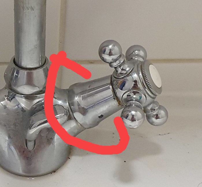 Kromad vattenblandare med runda rattar markerad med röd cirkel vid muttern där krankäglor sitter.